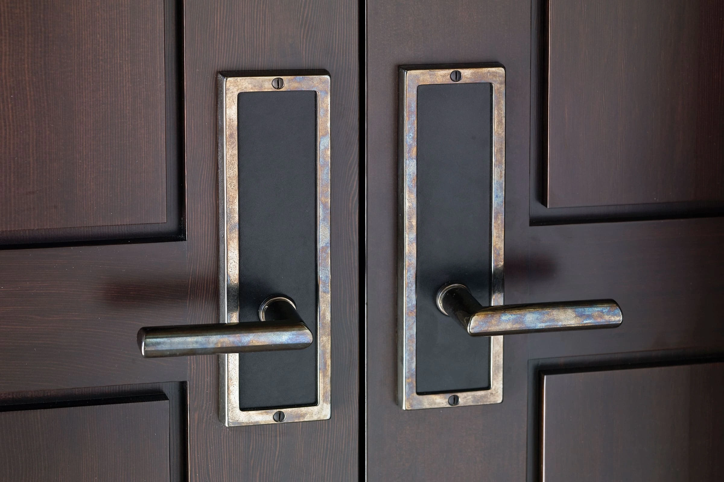 Hammered solid bronze escutcheons and levers on a pair of panelled doors